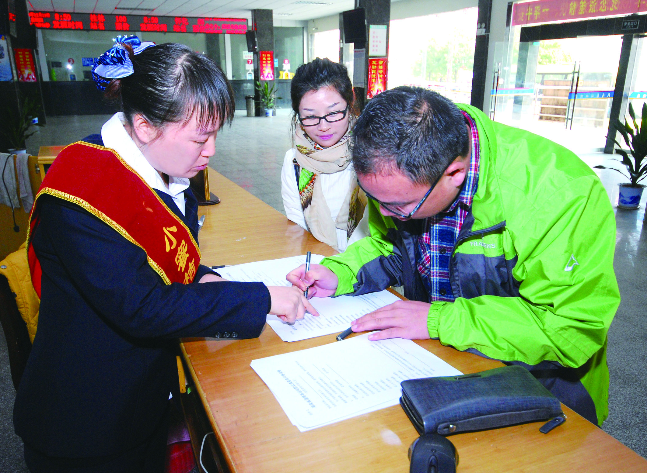 圖為洞口汽車總站站務(wù)人員在熱心為旅客服務(wù)。