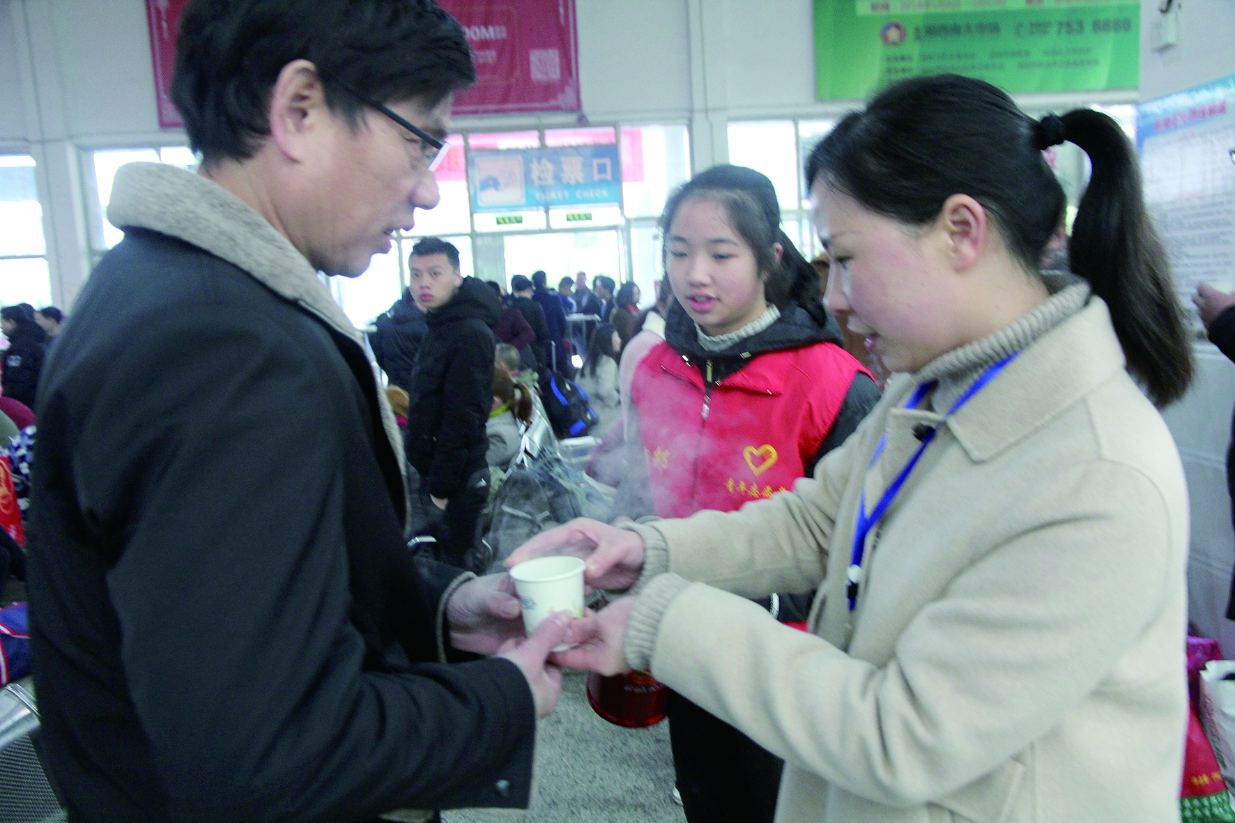 母女服務(wù)春運(yùn) 2月13日，記者在新邵分公司汽車(chē)站看到，該分公司安全科副科長(zhǎng)李喜梅與其在新邵一中初中部1701班就讀女兒劉嘉怡在車(chē)站擔(dān)當(dāng)志愿者。李喜梅在候車(chē)室耐心為旅客釋疑解惑，劉嘉怡為旅客遞上一杯杯熱茶，有時(shí)母女也相互合作，其樂(lè)融融。 祖冠 攝影報(bào)道